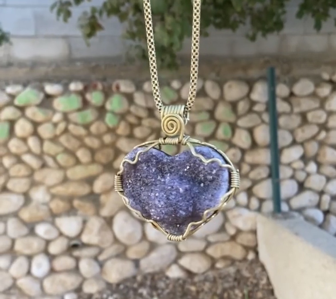 Amethyst druzy heart pendant in a garden