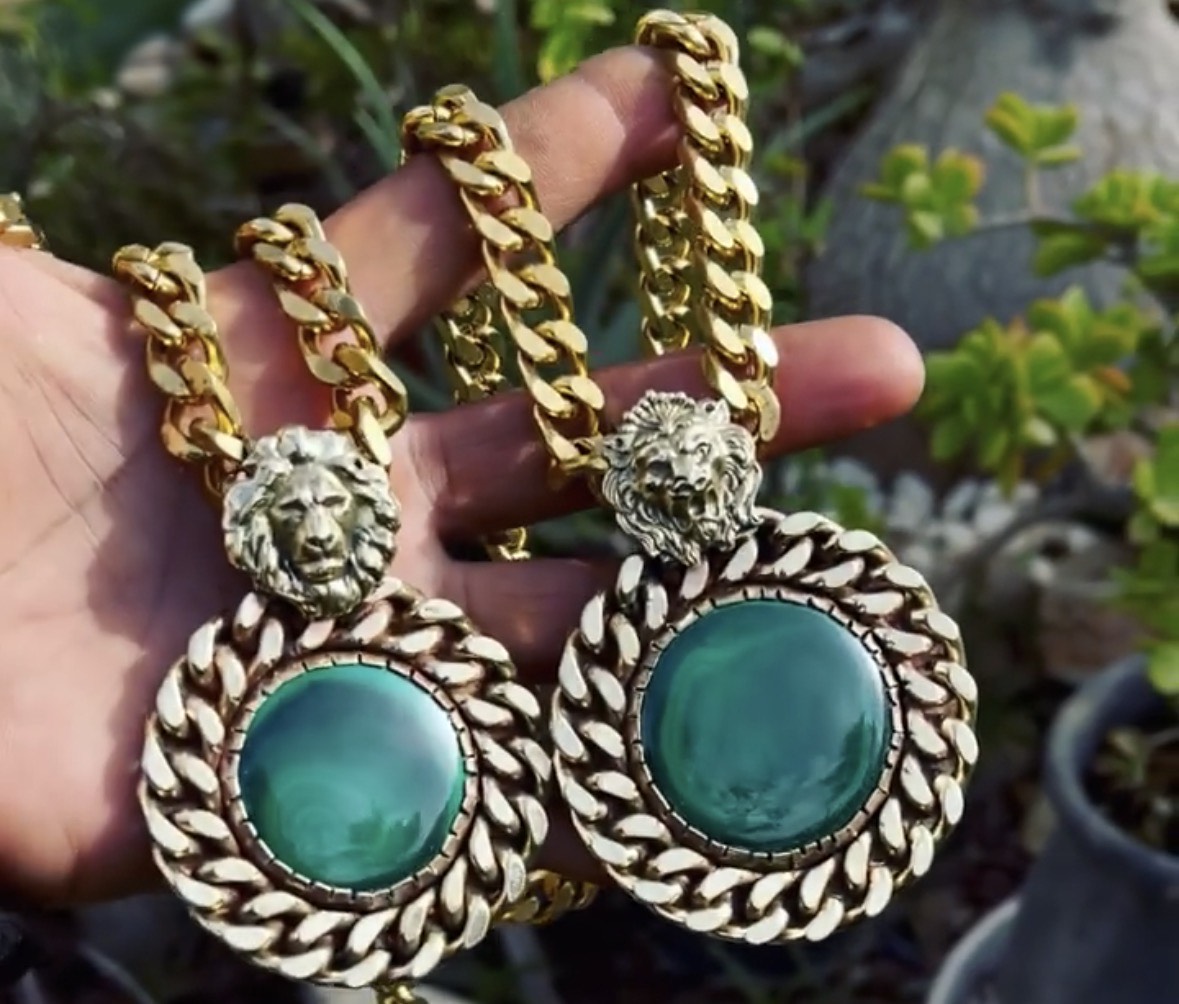 Two green stone lion-head pendants